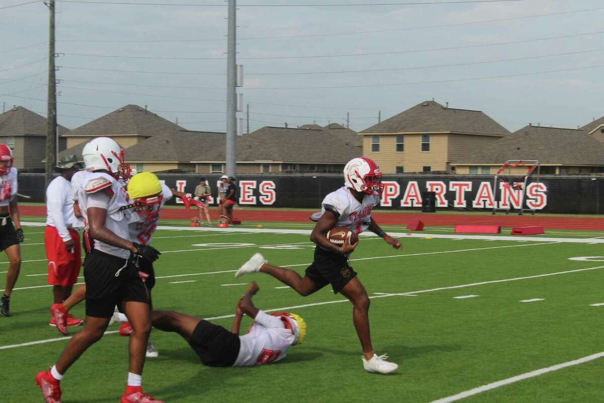 Cy Lakes running back Kyree Anderson runs over a defender during football practice, Tuesday, August 20, at Cypress Lakes High School.