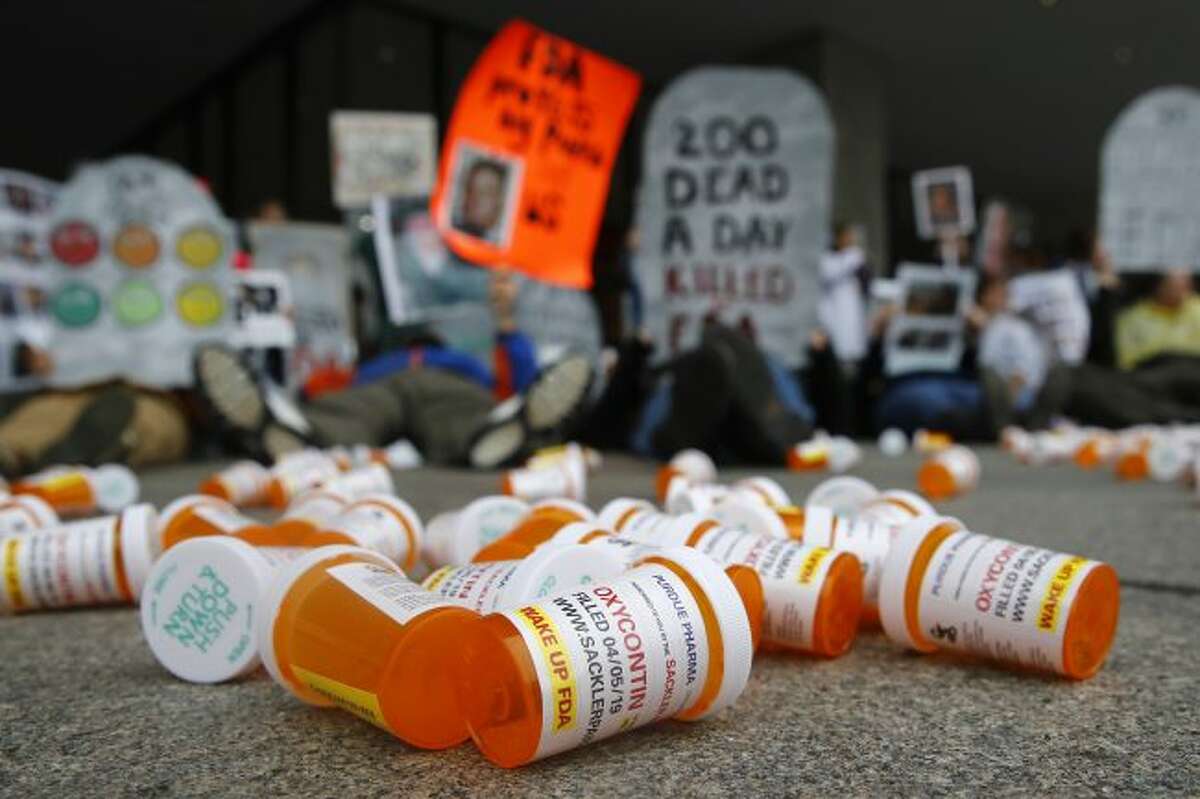 FILE - In this April 5, 2019, file photo, containers depicting OxyContin prescription pill bottles lie on the ground in front of the Department of Health and Human Services' headquarters in Washington as protesters demonstrate against the FDA's opioid prescription drug approval practices.