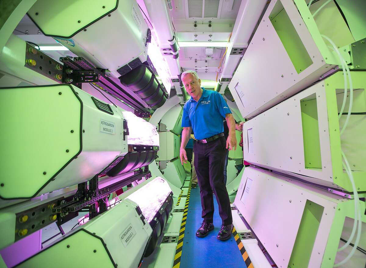Former NASA astronaut, space shuttle commander and current Sierra Nevada Corporation (SNC) vice president Steve Lindsey leads a tour of SNC's prototype for an inflatable space habitat that could be used for NASA's lunar orbital platform gateway project, during a press event at Johnson Space Center in Houston, Wednesday, Aug. 21, 2019. The purple glow comes from a vegetable growing system on display that SNC designed and is currently operating on the International Space Station. The habitat is designed to fit inside the cargo area of a commercial launch vehicle and then be inflated and outfitted in space. The habitat as currently modeled consists of three floors outfitted for a crew of four astronauts.