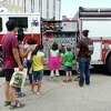 Children and parents look at some of the functions on a fire engine Saturday morning. The Fire Museum of Texas celebrated Smokey the Bear's 70th birthday Saturday morning with birthday cake and an appearance by Smokey. Photo taken Saturday 8/16/14 Jake Daniels/@JakeD_in_SETX