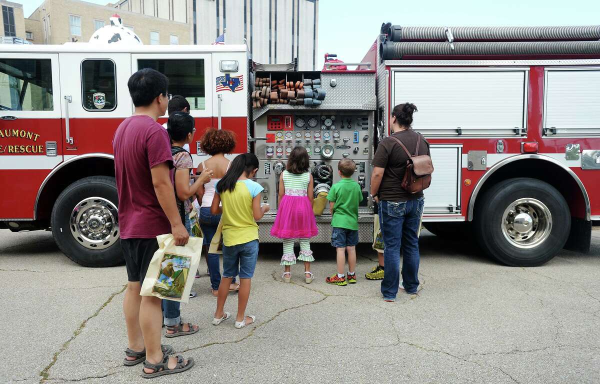 Children and parents look at some of the functions on a fire engine Saturday morning. The Fire Museum of Texas celebrated Smokey the Bear's 70th birthday Saturday morning with birthday cake and an appearance by Smokey. Photo taken Saturday 8/16/14 Jake Daniels/@JakeD_in_SETX