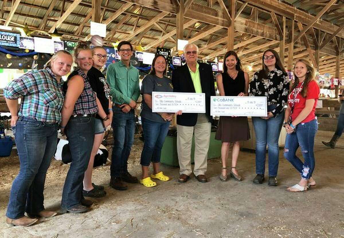 Edwin H. Eichler of Agri-Valley Communications and Jacqueline Bove of CoBank (fourth and third right) present checks totaling $4,000 to Ubly Community Schools teacher and FFA advisor Melissa Kramer (center) and her FFA students. The funds will assist in the construction of the district's new FFA barn.
