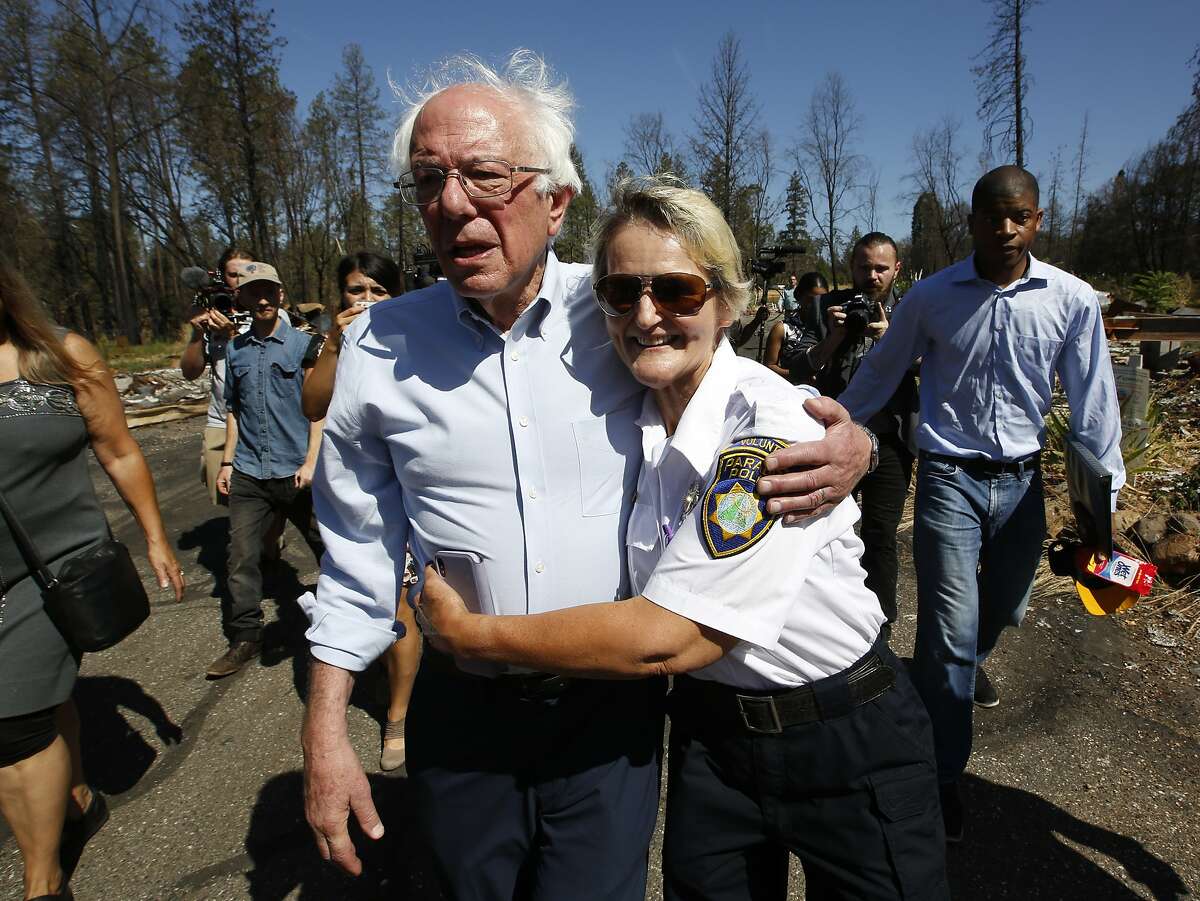 Democratic presidential candidate Sen. Bernie Sanders, I-Vermont, is hugged by Geralynne Radar, a volunteer with the Paradise Police Department, as he tours a mobile home park destroyed by last year's wildfire fire in Paradise, Calif., Thursday, Aug. 22, 2019. (AP Photo/Rich Pedroncelli)