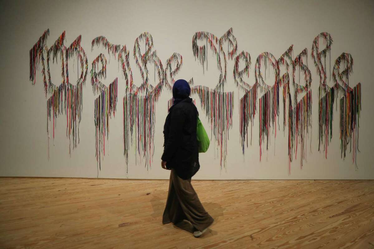 A visitor at the Contemporary Arts Museum Houston views the title work of the exhibition "We the People," which was ‘drawn’ by punching more than 3,500 shoestrings through drywall. The show features 25 years’ worth of work by American artist Nari Ward.