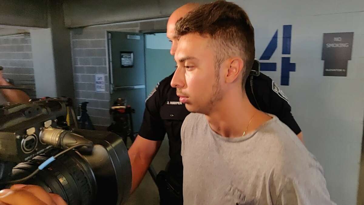 Sebastian Angel Espinar, 20, is charged with capital murder in the death of Andres Gerardo Salinas, 22, according to San Antonio Police. He is seen being escorted by officers to a police vehicle Thursday afternoon, Aug. 22, 2019, in the parking garage of the Public Safety Headquarters, 315 S. Santa Rosa Ave.
