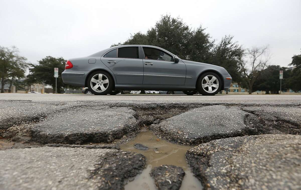 A driver makes their way past a pothole along Westheimer Road, near Eastside Street, Wednesday, Feb. 4, 2015, in Houston. (Cody Duty / Houston Chronicle)