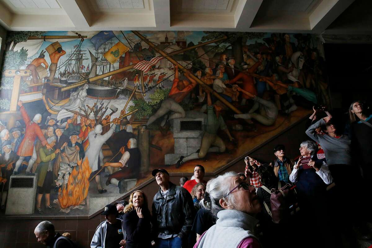 Vanya Akraboff (l to r) of Sausalito and Jeff Nemy discus the 1936 mural depicting the life of George Washington by San Francisco artist Victor Arnautoff at George Washington High School as Jean Amos of San Francisco views it during a public viewing on Thursday, August 1, 2019 in San Francisco, Calif.