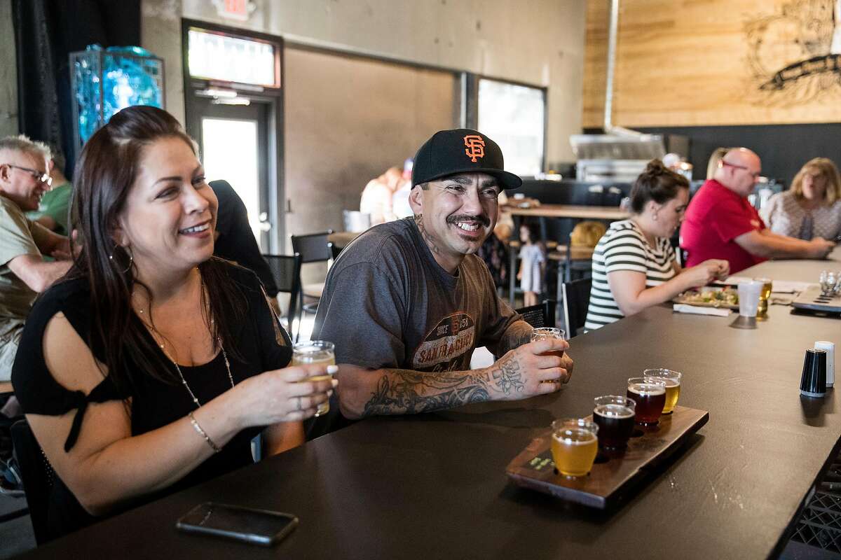 Maricela Gomez (left) and Ray Puentes enjoy a tasting flight of beer at High Water Taproom in Lodi, Calif., on Saturday, August 17, 2019. The taproom is brand new and was having a soft opening in August. The taproom features 36 taps, a full kitchen and an outdoor beer garden.