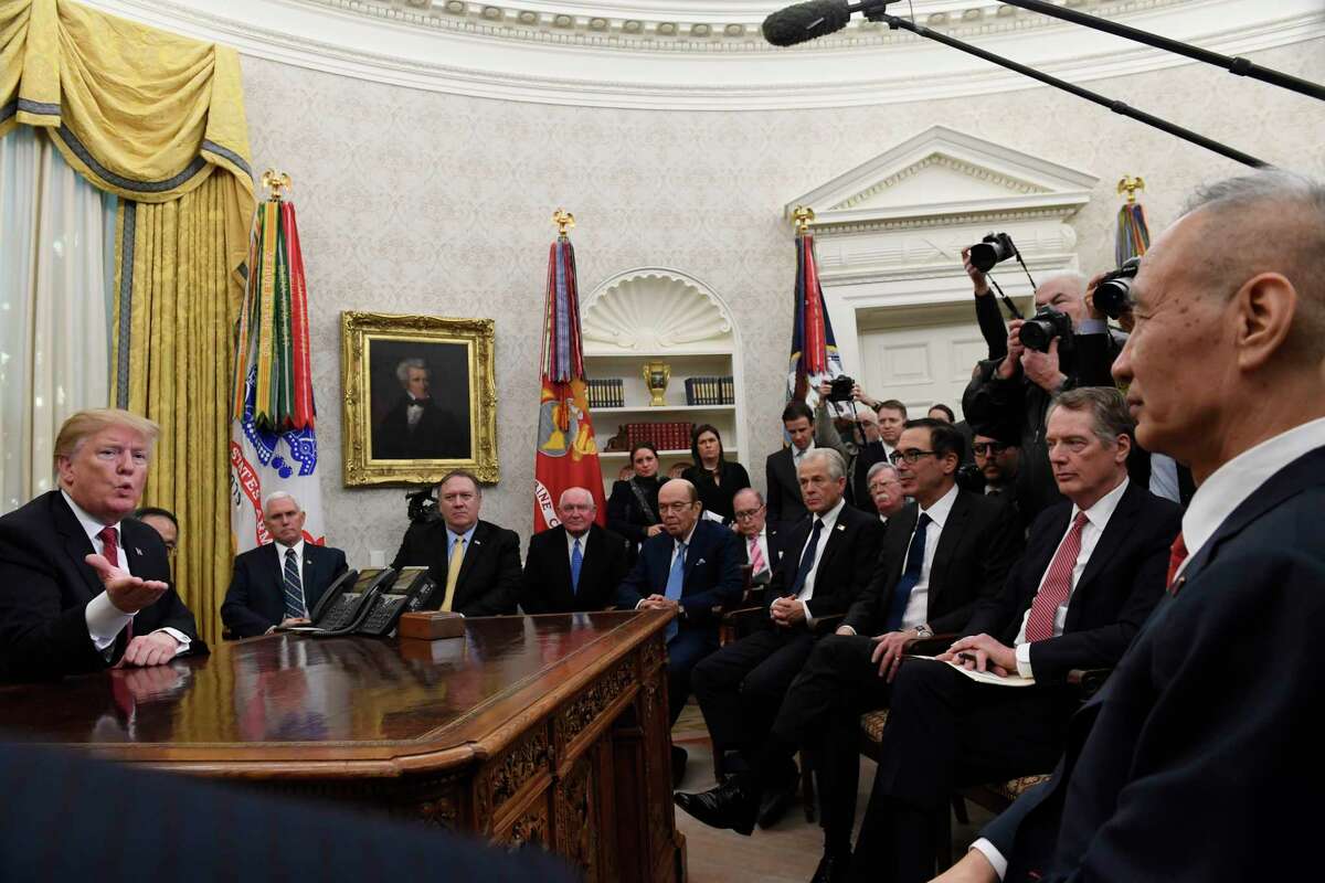FILE - In this Jan. 31, 2019, file photo, President Donald Trump, left, holds a meeting with Chinese Vice Premier Liu He, right, in the Oval Office of the White House in Washington. Also attending the meeting, starting third from left seated, are, Vice President Mike Pence, Secretary of State Mike Pompeo, Agriculture Secretary Sonny Purdue, Commerce Secretary Wilbur Ross, White House economic adviser Larry Kudlow, White House trade adviser Peter Navarro, national security adviser John Bolton, Treasury Secretary Steven Mnuchin, and U.S. Trade Representative Robert Lighthizer. (AP Photo/Susan Walsh, File)