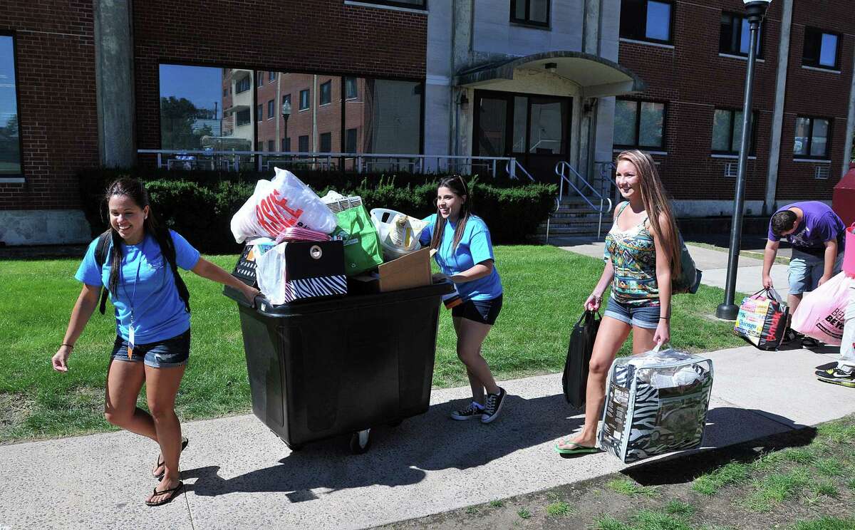 SCSU seniors Alyne Rodrigues, left, and Sarah Anderson, help bring in luggage for freshman Madison Macke, right, of Berlin, to the Chase Hall Dormitory. The students were arriving most of the day Saturday for the fall semester at Southern Connecticut State University.