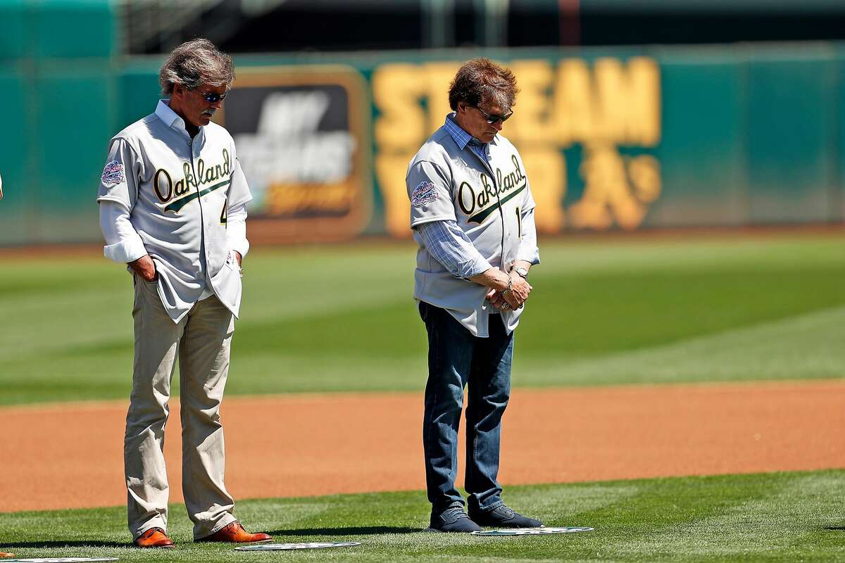 Oakland Athletics' Dennis Eckersleyand Tony LaRussa bow their heads during moment of silence for earthquake victims during ceremony honoring 1989 World Series champions before A's played San Francisco Giants in MLB game at Oakland Coliseum in Oakland, Calif., on Sunday, August 25, 2019.