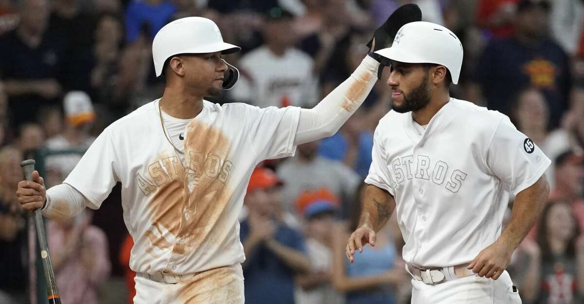 Houston Astros Yuli Gurriel, left, and Abraham Toro, right, celebrate scoring on a double hit by Josh Reddick against the Los Angeles Angels during the eighth inning of MLB game at Minute Maid Park Sunday, Aug. 25, 2019, in Houston.