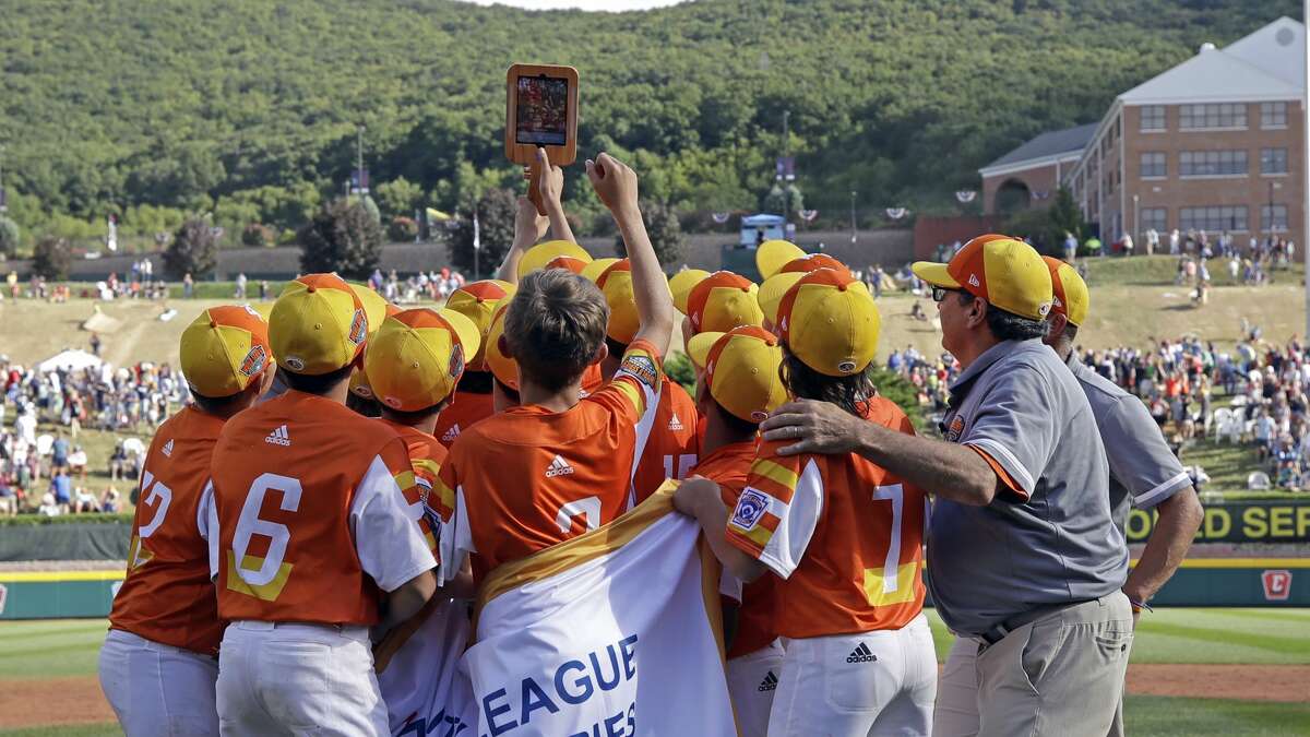 River Ridge, Louisiana take a selfie with the championship banner after defeating Curacao 8-0 in the Little League World Series Championship baseball game in South Williamsport, Pa., Sunday, Aug. 25, 2019. (AP Photo/Tom E. Puskar)
