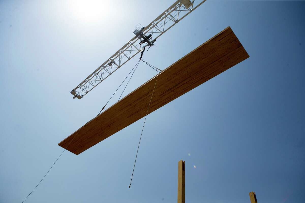A floor piece is lifted above the Soto by a crane on Aug. 15, 2019. The building has more wood — 640 cubic meters — than usual for a six-story building and uses less steel and concrete. The wood was harvested from tree farms in Canada and Austria specially grown for mass timber construction. The wood is formed into massive beams and columns that are shipped to the building site and assembled there.