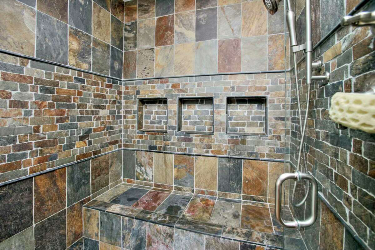 In the master bath there is a large stone tiled walk-in shower with a built-in bench.