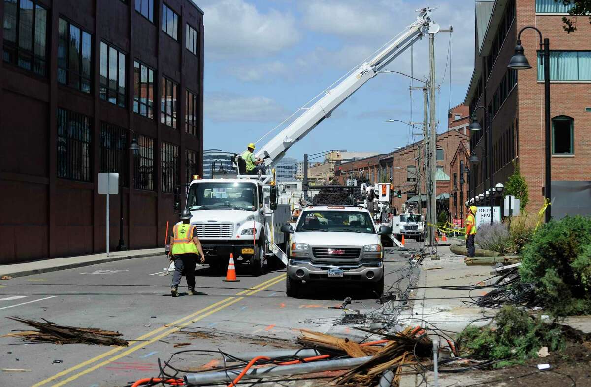 Utility crews from Eversource Power and Frontier Cable work to repair and replace broken utility poles following a car crash in the South End of Stamford along Canal Street resulting in two confirmed fatalities, and four other individuals injured in the morning hours of Monday, August 26, 2016.