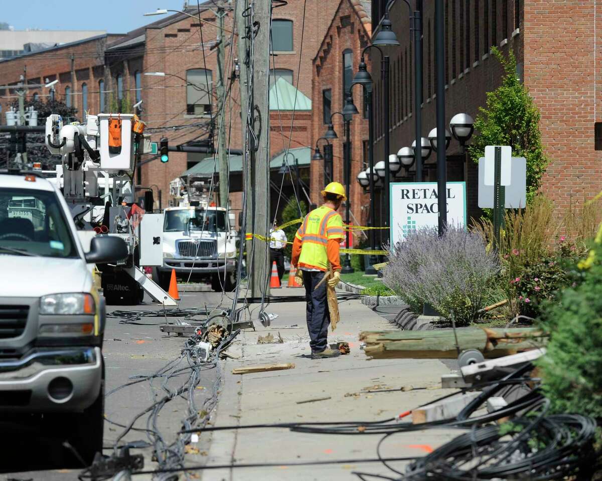 Utility crews from Eversource Power and Frontier Cable work to repair and replace broken utility poles following a car crash in the South End of Stamford along Canal Street resulting in two confirmed fatalities, and four other individuals injured in the morning hours of Monday, August 26, 2016.