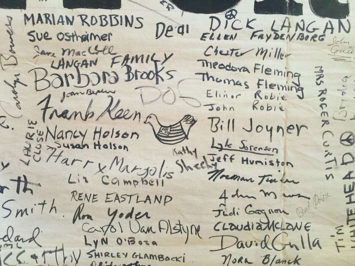 A drawing of a dove and peace signs were scattered among signatures on the 1969 Vietnam War protest banner on display at the Wilton Historical Society.