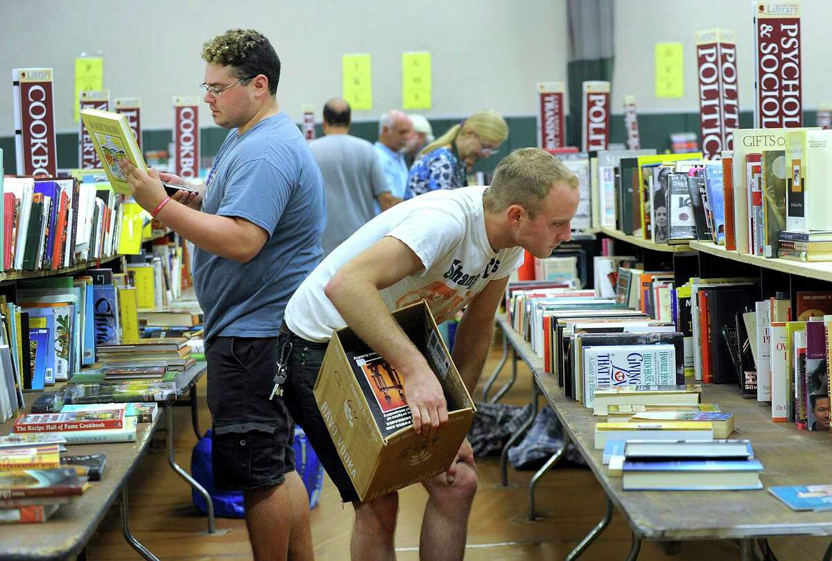 First comers at the opening of the doors to the Redding Community Center Friday morning - mostly dealers and collectors - pour through the thousands of books, vinyl record and other items at the 58th Annual Mark Twain Library Book Fair, August 31, 2018.