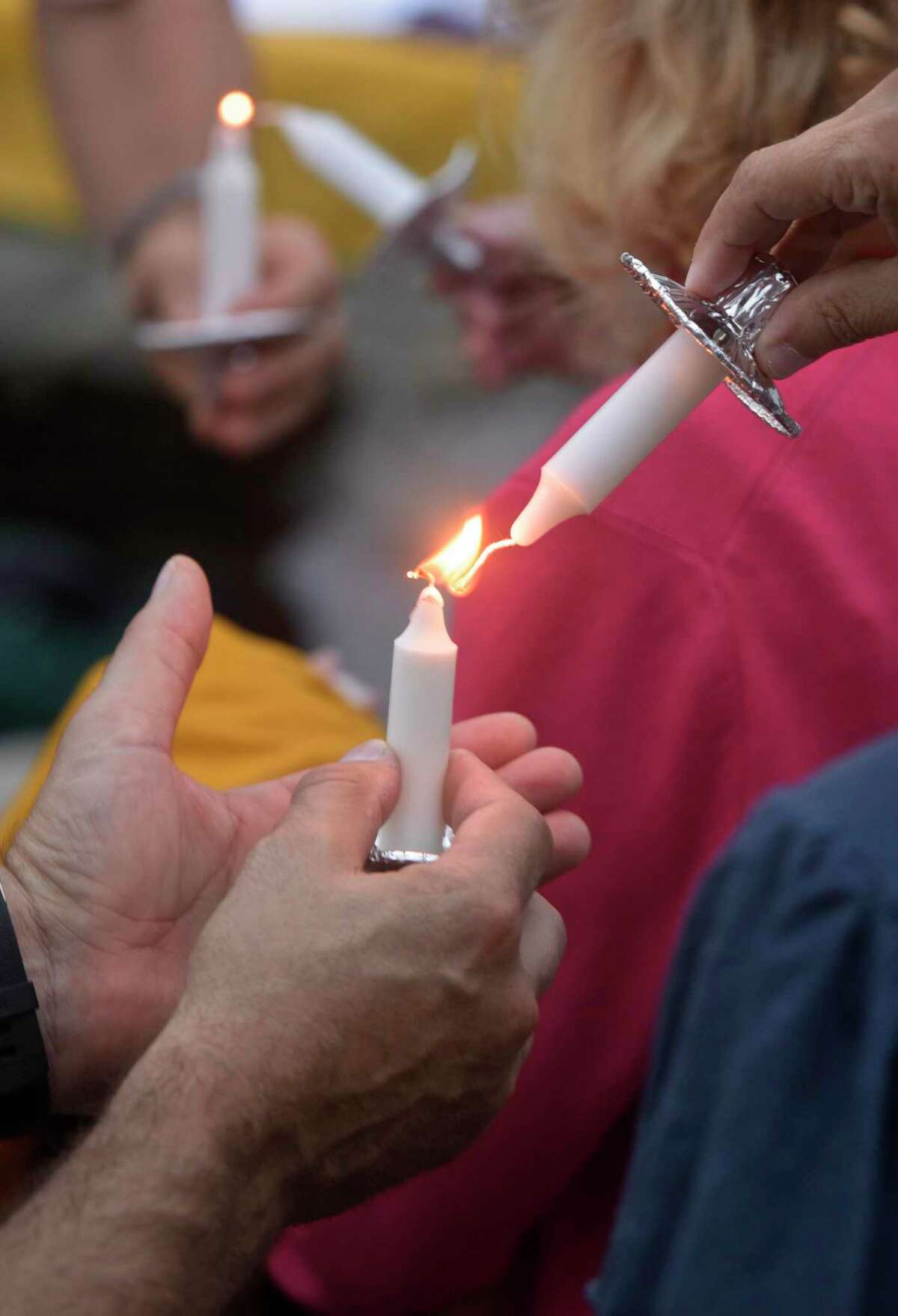 File photo of a people lighting candles from one another during The Heroin and Opiate Awareness Project (HERO) annual vigil to raise awareness of overdoses, held on the same day as International Overdose Awareness Day. Friday, August 31, 2018, at United Methodist Church, Bethel, Conn.