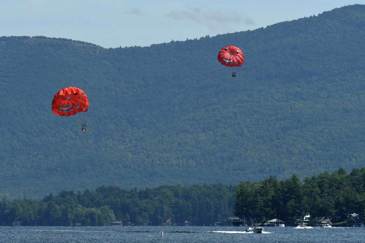 Tourist take a parasail ride high above Lake George on Tuesday, Aug. 27, 2019, in Lake George, N.Y. The Lake George Park Commission listened to public comments Tuesday on commercial parasailing safety concerns following an accident earlier this summer. (Will Waldron/Times Union)
