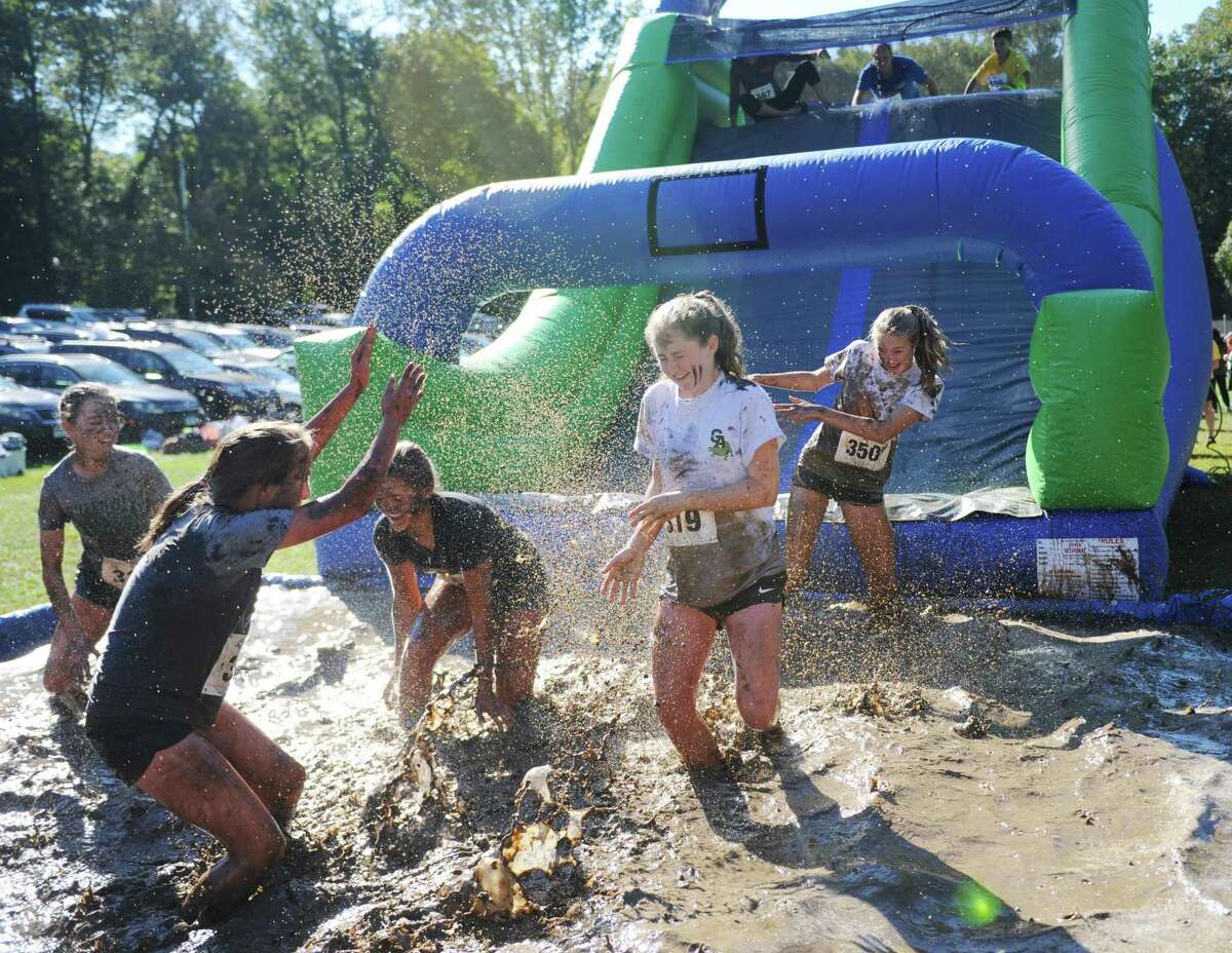 Photos from the Muddy Up 5K Run and Family Walk at Camp Simmons in Greenwich, Conn. Sunday, Oct. 1, 2017. Hundreds of participants ran through the course full of man-made obstacles including several mud pits. Proceeds from the event benefited the Boys & Girls Club of Greenwich.