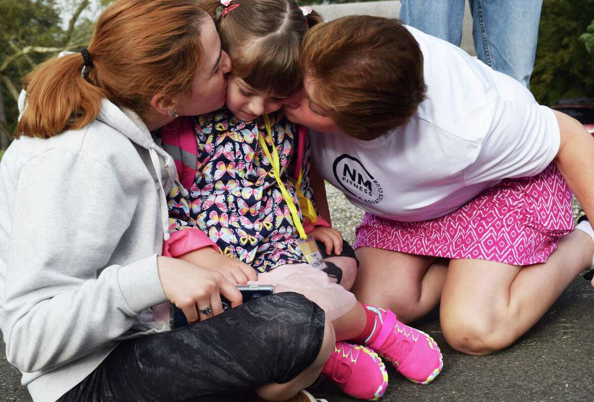 Spectrum/New Milford students headed back to school Tuesday, Aug. 27, 2019. Above, Victoria Trenck is showered with love by family members Kristina, left, and Kim, before getting on the bus for her first day of kindergarten at Hill and Plain Elementary School.