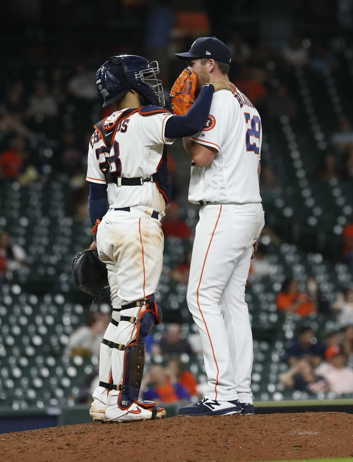 Houston Astros catcher Robinson Chirinos (28) chats with relief pitcher Joe Biagini (29) after he gave up a single to Tampa Bay Rays Eric Sogard during the ninth inning of an MLB baseball game at Minute Maid Park, Tuesday, August 27, 2019.