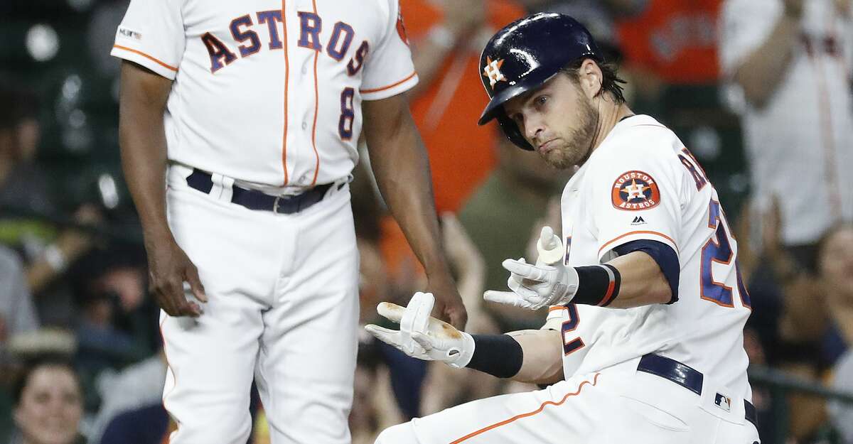 Houston Astros Josh Reddick (22) flashes his spiderman pose at third base after his triple during the fourth inning of an MLB baseball game at Minute Maid Park, Tuesday, August 27, 2019.