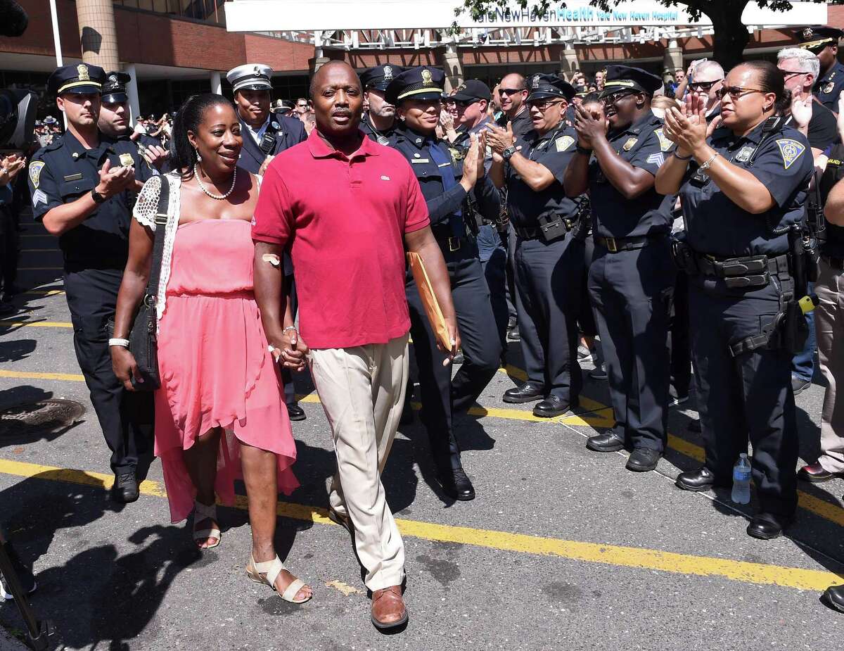 Members of the New Haven Police Department applaud as Captain Anthony Duff leaves Yale New Haven Hospital with his wife on August 22, 2019 a week after he was shot intervening in a shooting while off-duty.