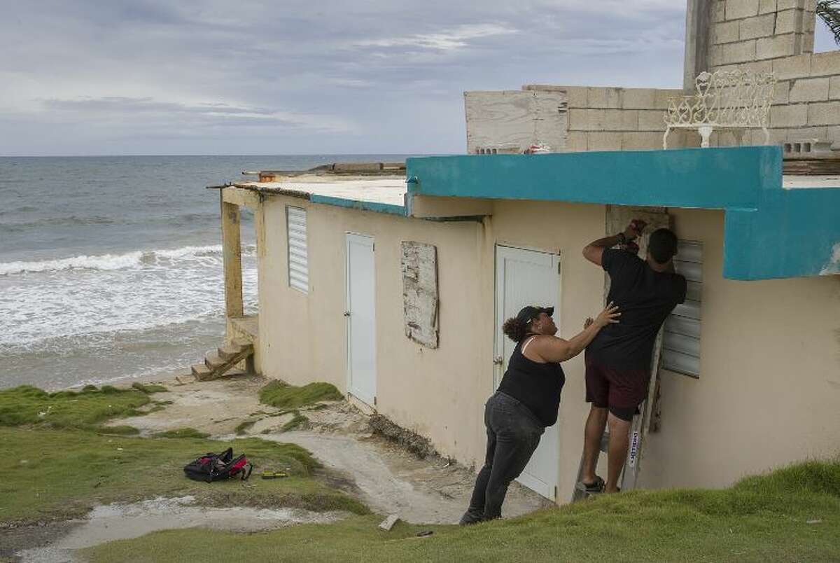 Ya Mary Morales (L) and Henry Sustache put plywood over the windows of their home as they prepare for the arrival of Tropical Storm Dorian on August 28, 2019 in Yabucoa, Puerto Rico.