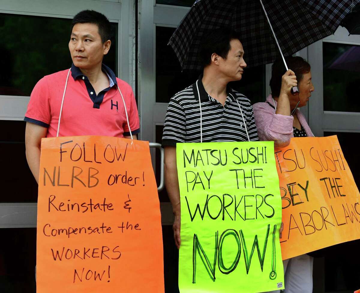 Matsu Sushi employees, protestors and labor leaders protest the firing two staff members during a picket of the restaurant Tuesday, August 13, 2019, in Westport, Conn. The two employees, Jianming Jiang and Liguo Ding, were fired in 2017 after they refused to work three consecutive shifts.