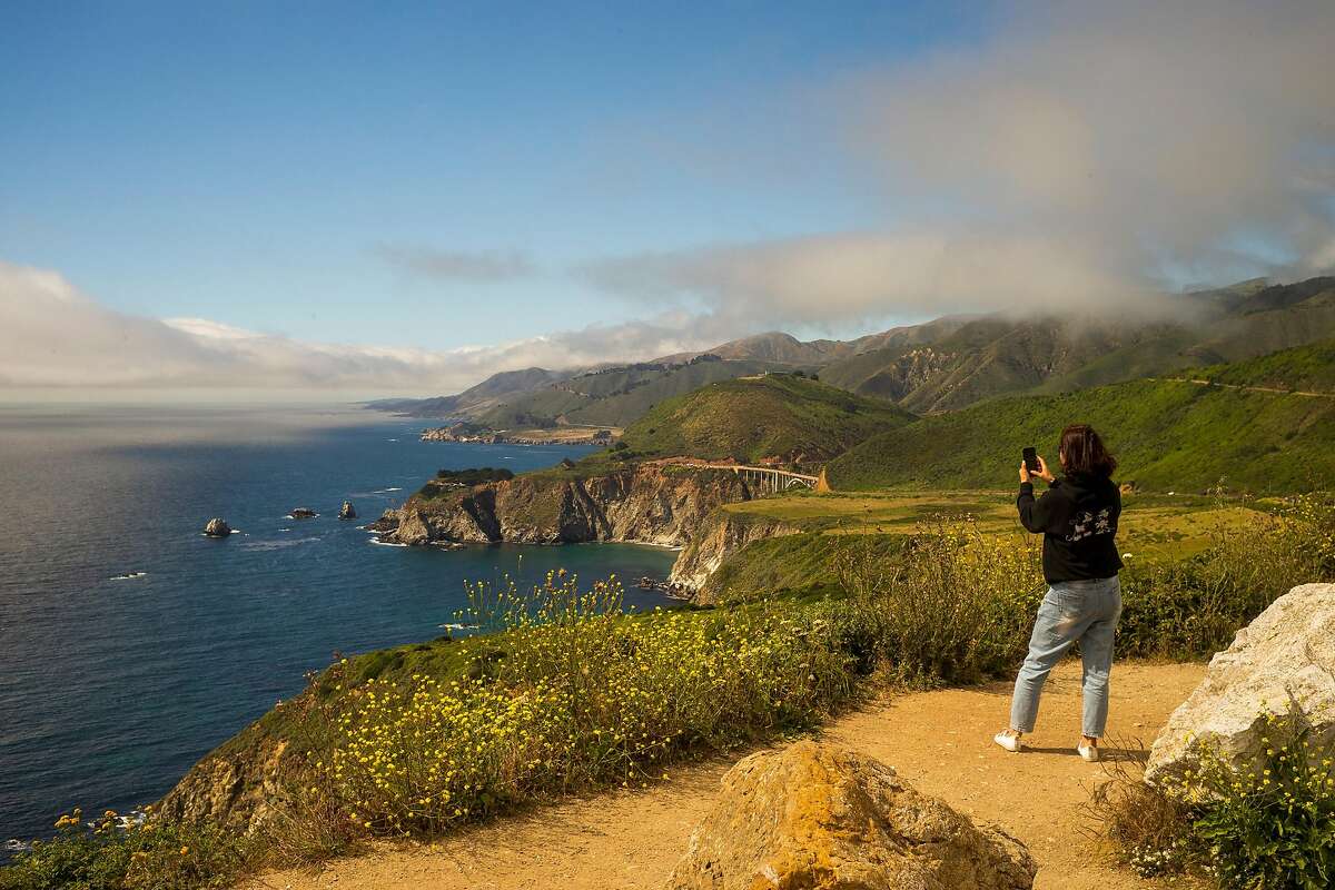 A woman takes a photo of Bixby Bridge from Hurricane Point in Big Sur, Calif. in June 2019.