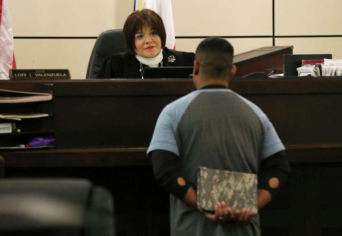 Judge Lori I. Valenzuela in the 437th State District Court discusses the progress of treatment for a military veteran on Thursday, Nov. 15, 2018. Valenzuela is part of two courts in Bexar County handle felony cases involving drunk driving and or drug crimes committed by military veterans called Felony Veterans Treatment Court. But instead of initially seeking punishment, the court looks to provide treatment options foremost. One of the courts is with Judge Lori I. Valenzuela in the 437th State District Court and the other is with Judge Jefferson Moore in 186th State District Court. The program is county funded and is nearing their first year of handling cases. On Thursday, Judge Valenzuela handled a typical docket with about a dozen military veterans mostly male and one female. She commended those who were nearing or completing their treatment programs and admonished those who have not progressed. At the conclusion of court, both Valenzuela and Moore invited veterans to cookies and pastries at an informal gathering. Case manager John Herman shuffles around the court attempting to get paperwork in order while Veterans Justice Outreach Coordinator at Department of Veterans Affairs Treva Neiss helps provide representation for the veterans in court. (Kin Man Hui/San Antonio Express-News)