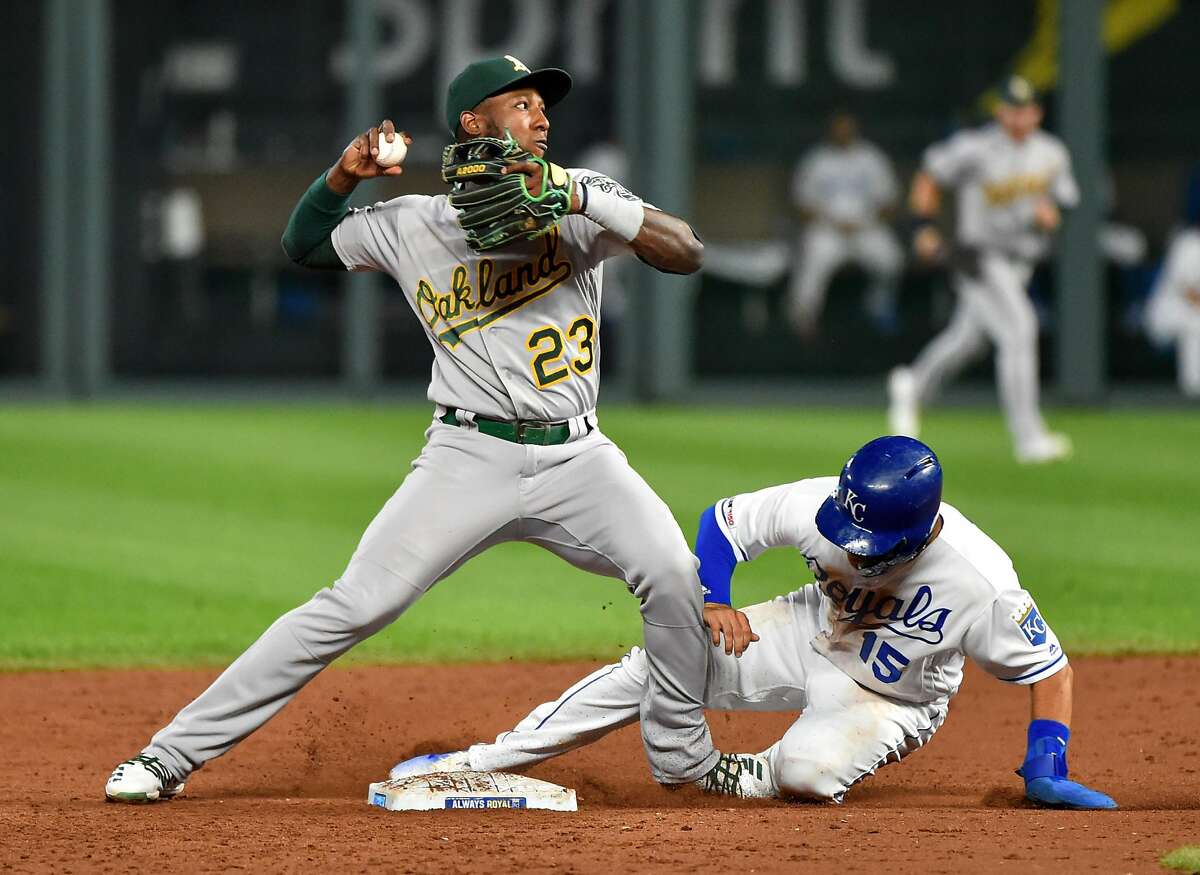 KANSAS CITY, MISSOURI - AUGUST 28: Second baseman Jurickson Profar #23 of the Oakland Athletics throws past Whit Merrifield #15 of the Kansas City Royals as he attempts to complete a double play in the third inning at Kauffman Stadium on August 28, 2019 in Kansas City, Missouri. Profar's throw was not in time and Jorge Soler was safe at first. (Photo by Ed Zurga/Getty Images)
