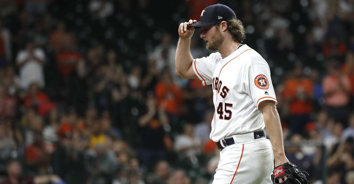 Houston Astros starting pitcher Gerrit Cole (45) walks back to the dugout after handing off the ball to manager AJ Hinch (14) during the seventh inning, after striking out 14 batters durng the an MLB baseball game at Minute Maid Park, Wednesday, August 28, 2019.
