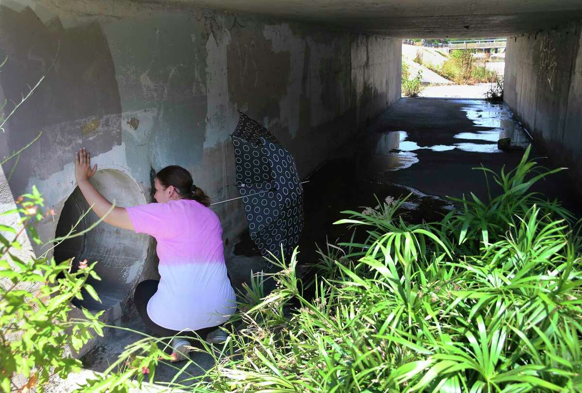 Mireya Lopez of Houston, who is the sister of Cecilia Huerta Gallegos, searches for clues in a drainage culvert as she joins Search & Support San Antonio to look for Gallegos on July 27, 2019. Gallegos, 30, is the mother of four children.