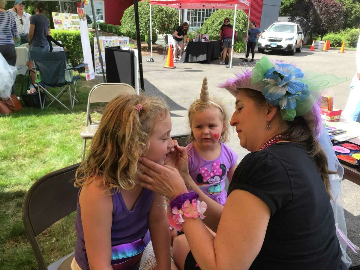 Goldie, 4, watches her sister, Alexa, 8, get her face painted at the Cannon Grange’s 87th annual agricultural fair and exposition on Sunday, Aug. 25. The sisters live in Westport.