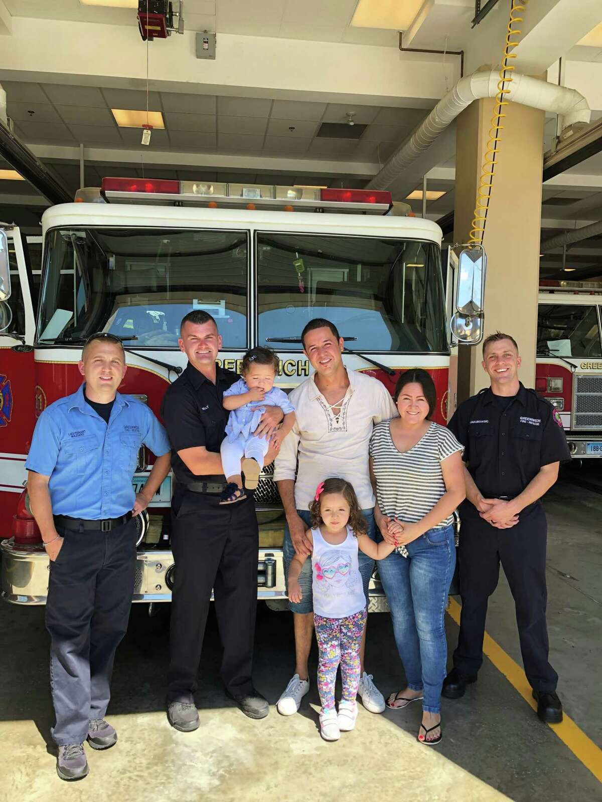 Erik Maziarz, Chris Kelly, Sophia Rincon, Juan Rincon, Luciana Rincon, aged 4, Luc Rincon and Adam Jakubowski meet at the downtown fire station Thursday. The firefighters helped revive the infant on Aug. 13, and her family came by to offer thanks.
