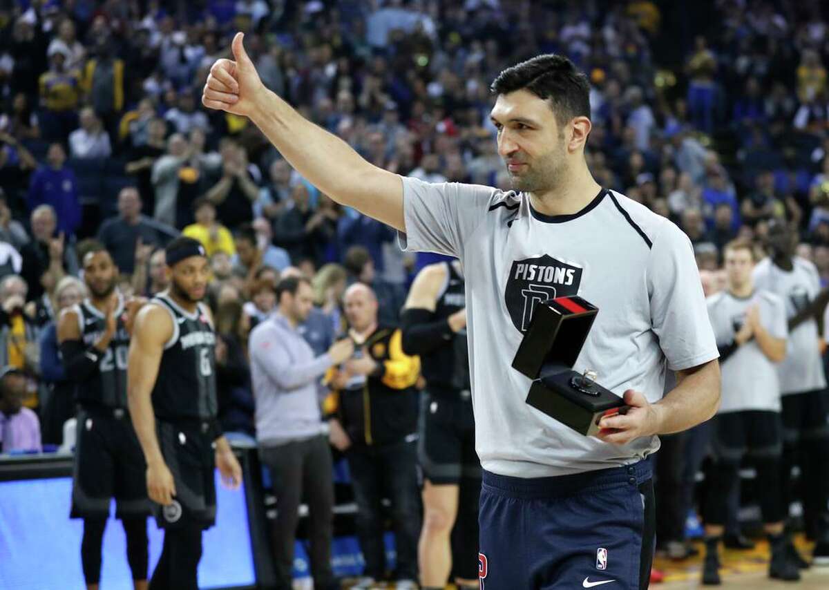 Detroit Pistons' Zaza Pachulia gives a thumbs up to the Golden State Warriors' bench after being presented his 2018 NBA Championship ring before NBA game at Oracle Arena in Oakland, Calif., on Sunday, March 24, 2019.