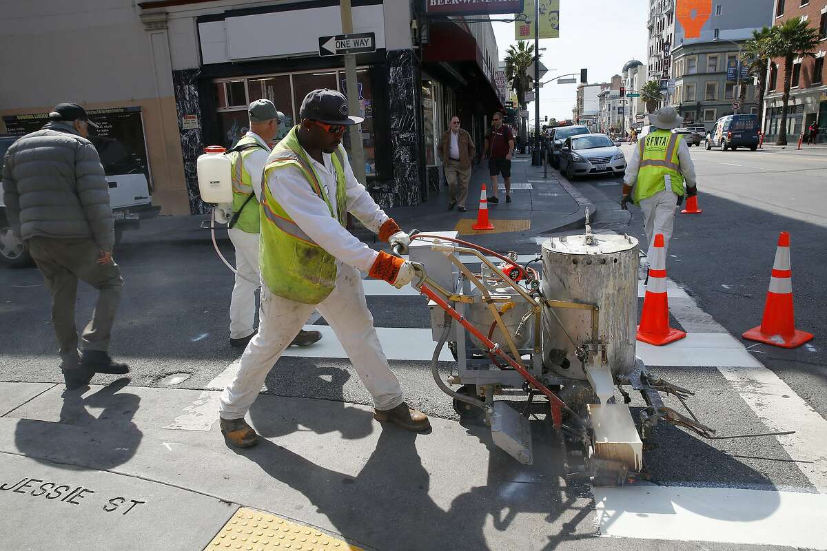 San Francisco Municipal Transportation agency employees paint more lines to pedestrian walks on 6th at Stevenson streets in San Francisco, Calif., on Wednesday, July 1, 2015. The Vision Zero plan is one of the city's projects to reduce pedestrian and bicyclists deaths to zero.