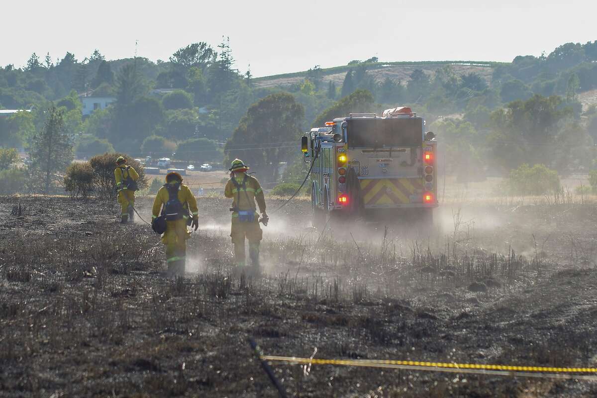 Firefighters secure the scene of a grass fire next door to The Meadows of Napa Valley Senior Facility, Thursday August 29, 2019, in Napa, Ca. Officials advised those with respiratory issues to stay indoors due to the smoke.