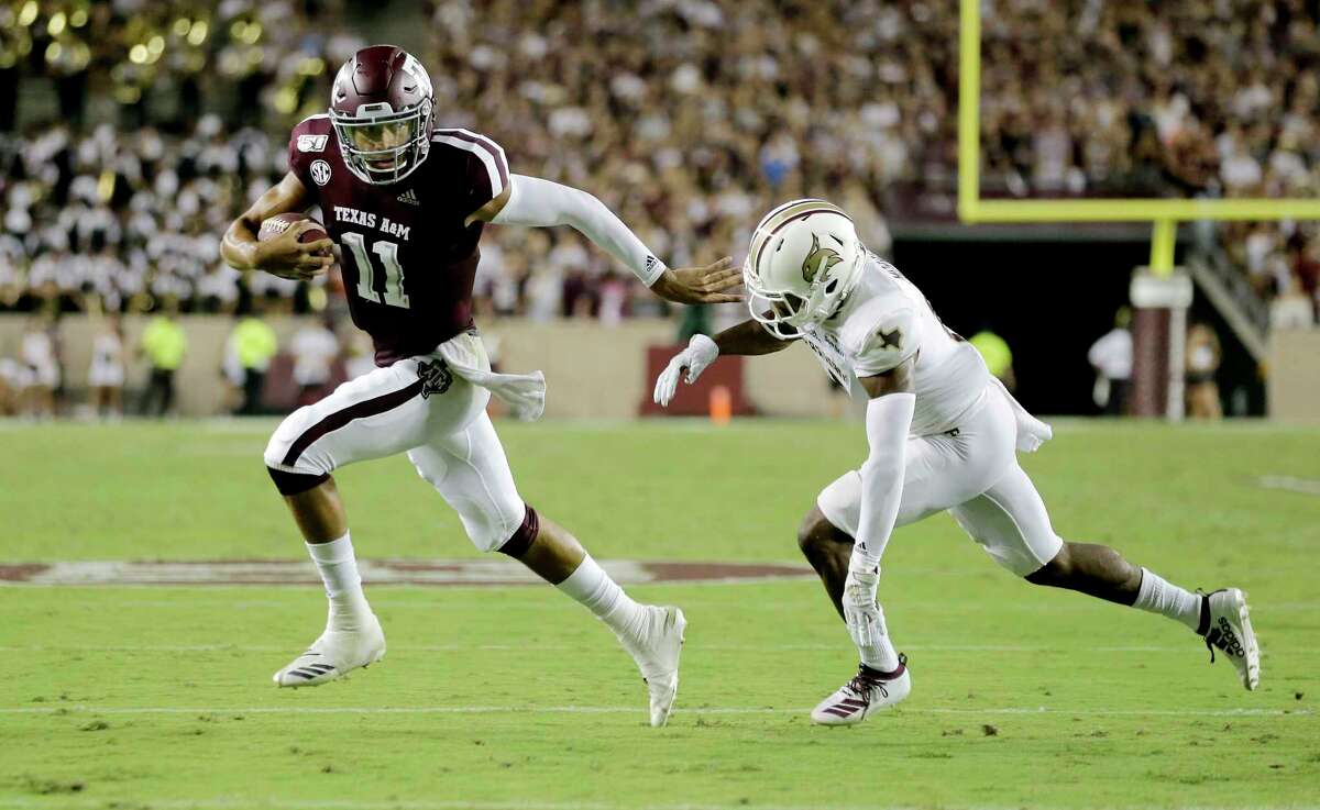 Texas A&M quarterback Kellen Mond (11) fights off Texas State defensive back Jarron Morris (15) while rushing for a touchdown during the first half of an NCAA college football game Thursday, Aug. 29, 2019, in College Station, Texas. (AP Photo/Sam Craft)