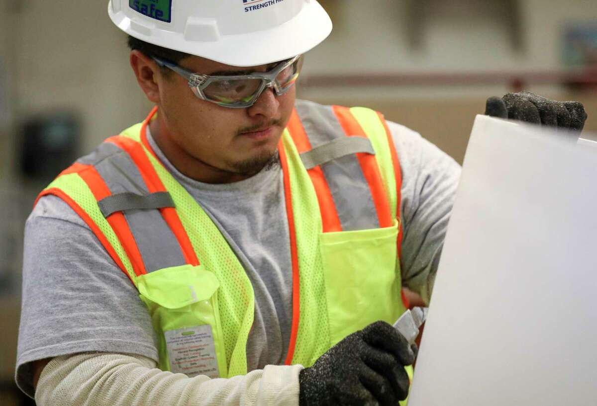 Pedro Briones cuts a sheet of drywall on Thursday, Aug. 29, 2019, in Houston.