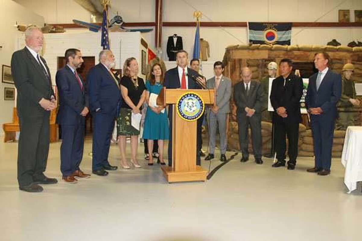 State legislators and others gather for the signing of a law to establish a Military to Machinist Program.