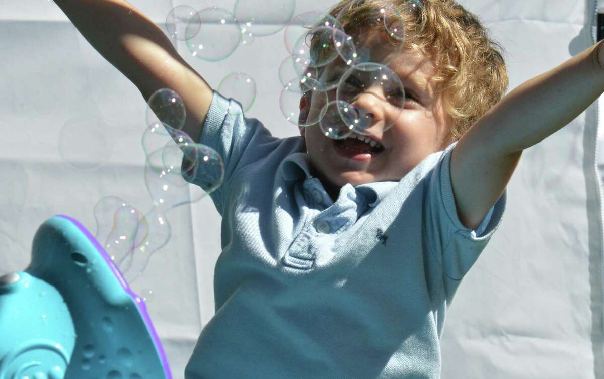Michael Voynick from Trumbull lgrabs at the bubbles coming from the Discovery Museum booth, during the Trumbull Arts Festival held on Sunday September 16, 2018 in Trumbull Conn. Fine artists, crafters, community booths and food trucks plus entertainment and a childrens creative center were all part of the activities at the Town Hall Green