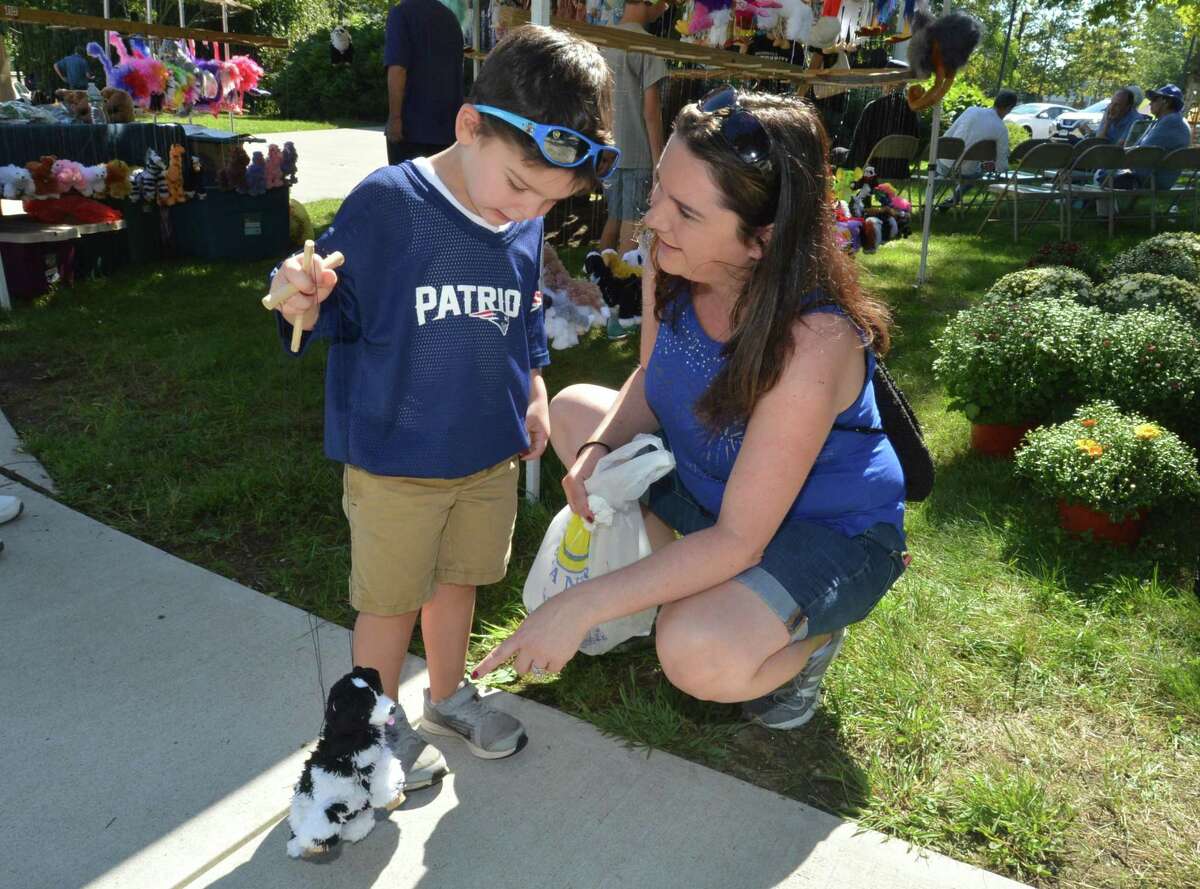 Alex Roldan trys to walk a marionette puppy dog with help from mom Kim during the Trumbull Arts Festival held on Sunday September 16, 2018 in Trumbull Conn. Fine artists, crafters, community booths and food trucks plus entertainment and a childrens creative center were all part of the activities at the Town Hall Green