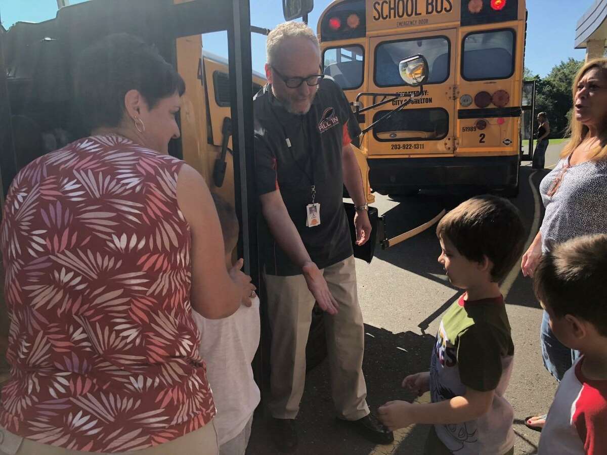 School Superintendent Chris Clouet high-fives kindergartners as they get on the bus on Aug. 30 at Elizabeth Shelton School.