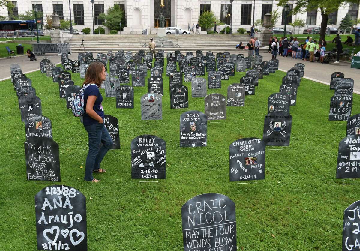Shauna Sitts of Broadalbin, who lost her brother Bryan Sheckton to an overdose in 2014, walks through a field of gravestones representing some of the state's population lost to overdose on Friday, Aug. 30, 2019, during Capital Region Overdose Awareness Day at events at West Capitol Park in Albany, N.Y. (Will Waldron/Times Union)