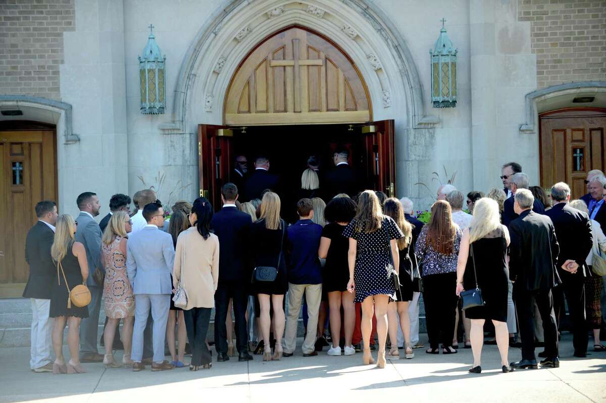 Family members bear the casket of Tim Currie, a beloved Norwalk business owner and musician, outside of St. Thomas the Apostle Church on Friday, Aug. 30, 2019.